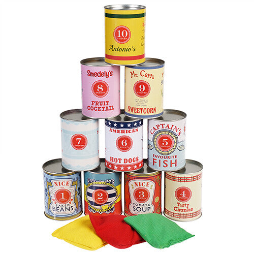 Rex London blikgooien spel met een piramide van 10 blikken met retro voedseletiketten en drie gekleurde zitzakjes op een witte achtergrond.