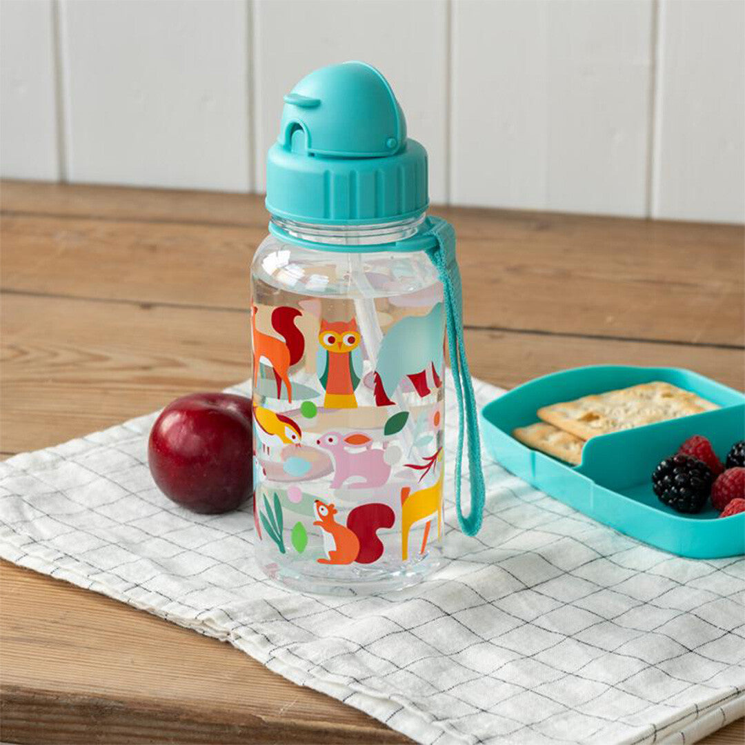 Rex London kinder drinkfles met rietje en woodland dieren op een tafel met een appel en lunchbox.
