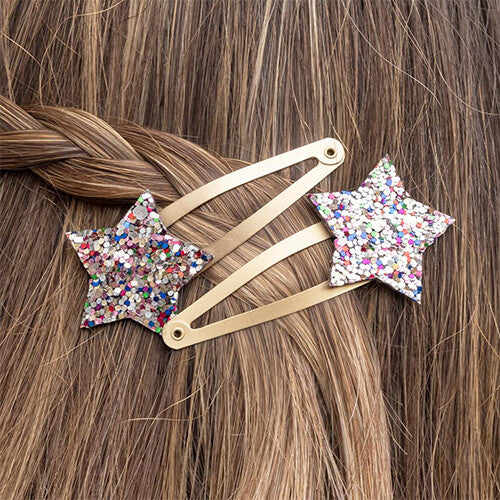 Twee haarspeldjes met glittersterren in gevlochten bruin haar.