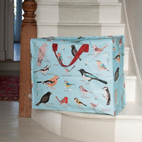 Rex London jumbo opbergtas met tuinvogelprint op een houten trap in een huiselijke omgeving.