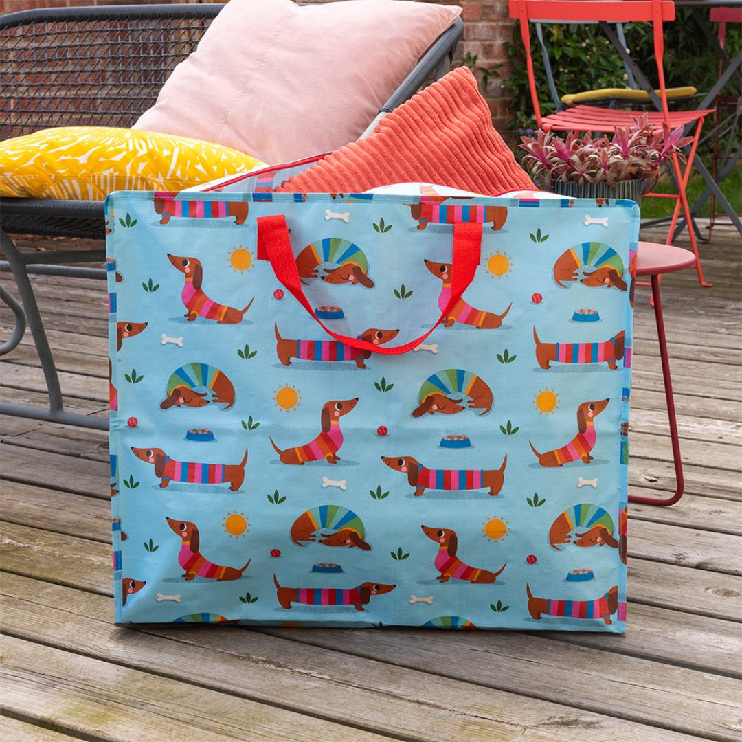 Rex London blauwe jumbo opbergtas met teckelpatroon staand op een houten terras.