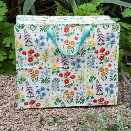 Rex London jumbo opbergtas met wild flowers patroon, staand op een grindpad in de tuin.