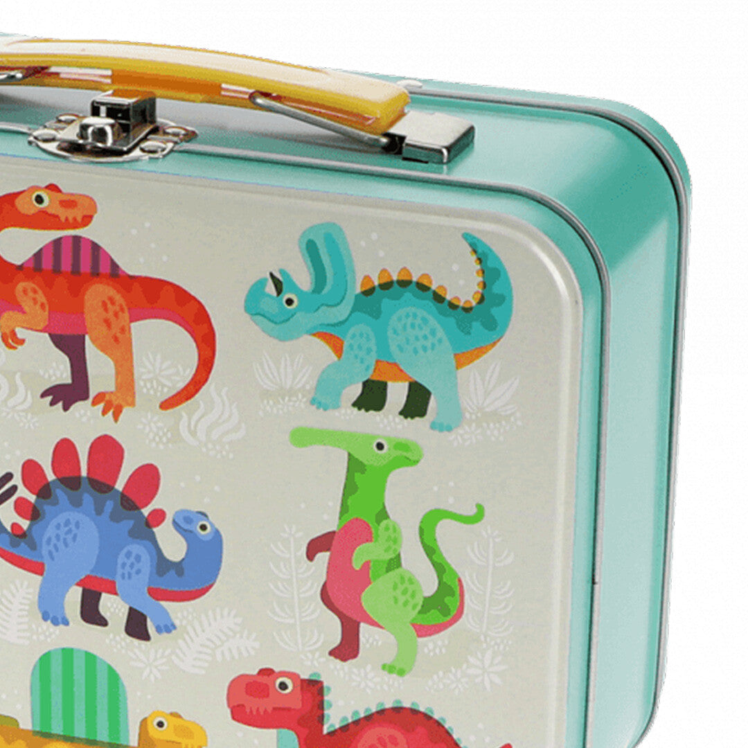 Detail van het Rex London metalen koffertje met gele handgreep en een blauwe dinosaurusillustratie.
