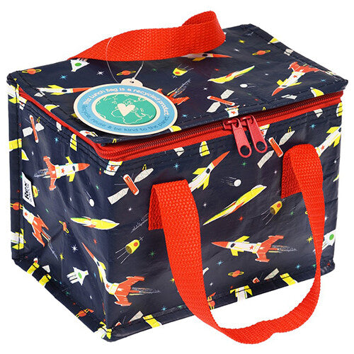 Rex London marineblauwe lunchtas voor kinderen met rakettenpatroon, schuin van bovenaf gefotografeerd.