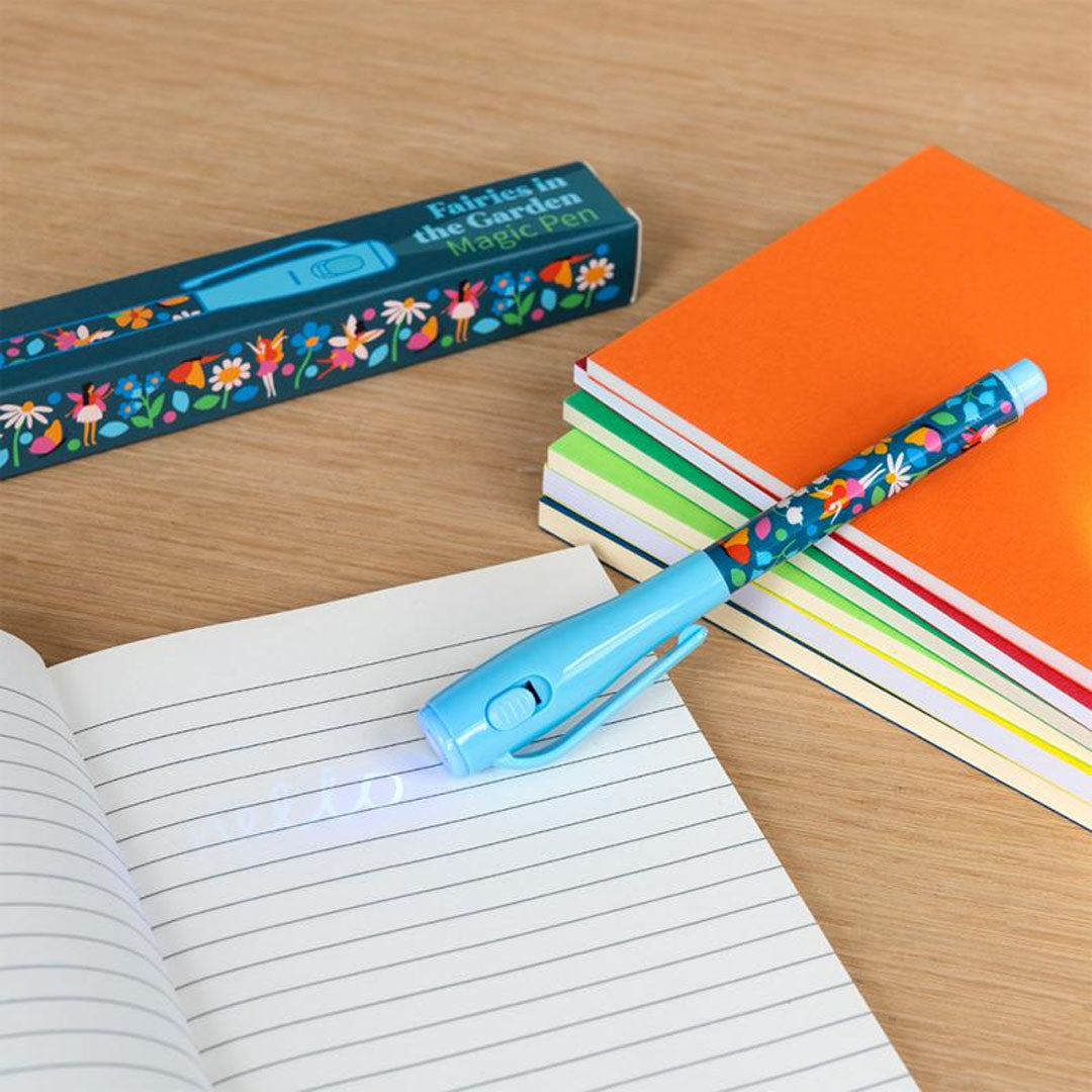 Rex London magische pen met feeën en bloemenpatroon die op een notitieboekje schrijft, met het lichtje aan.