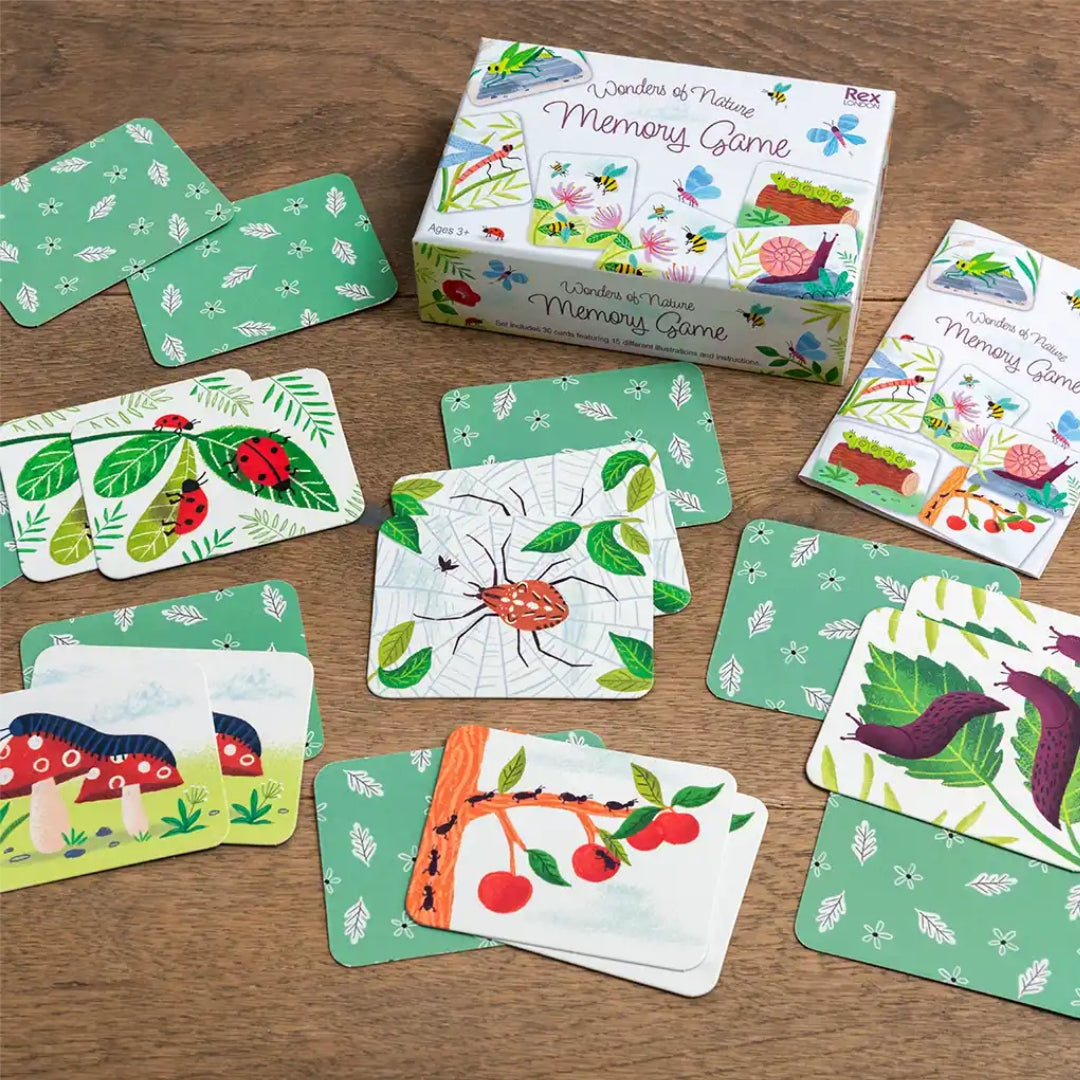 Rex London Wonders of Nature memory game kaarten liggen verspreid op een houten ondergrond, met de doos op de achtergrond.