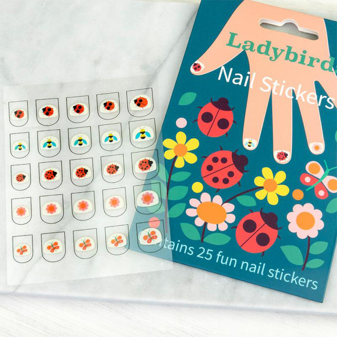 Rex London nagelstickers lieveheersbeestje, een close-up van het vel met diverse lieveheersbeestje-, bijen- en bloemstickers naast de verpakking.