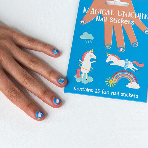 Een hand met aangebrachte Rex London eenhoorn nagelstickers naast de productverpakking.