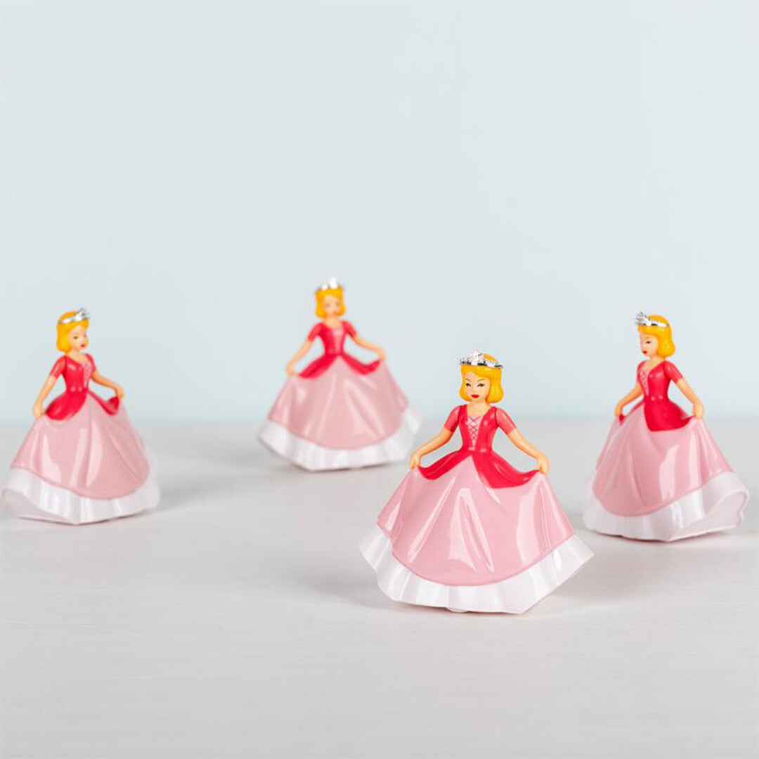 Vier identieke opwindbare prinses speelfiguren met roze jurken en tiara's, schuin van bovenaf gefotografeerd.