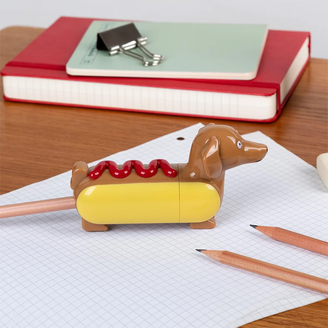 De Rex London hot dog puntenslijper slijpt een potlood op een geruit blaadje.