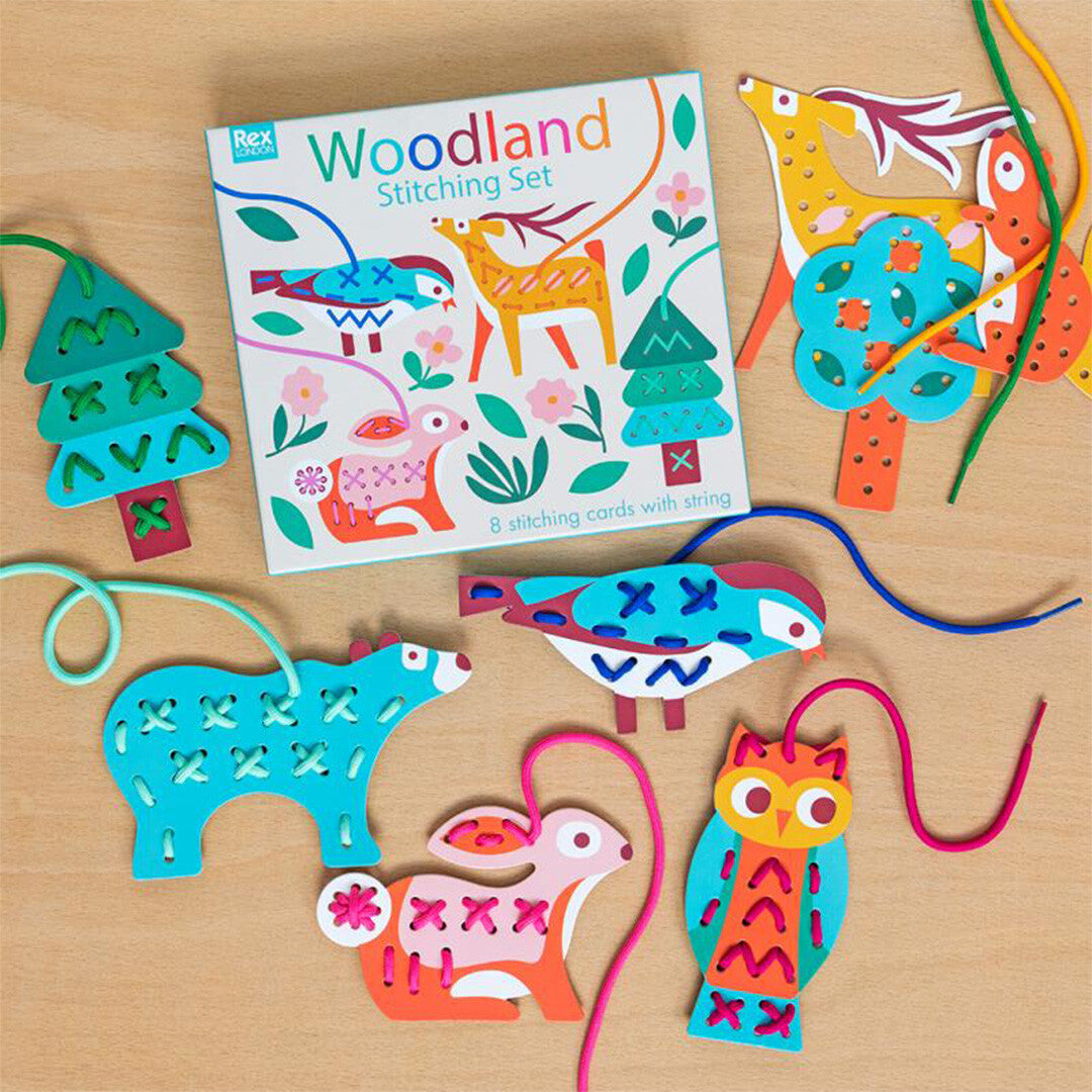 Rex London Woodland rijgkaarten hobbyset met diverse geregen dierenfiguren en de verpakking op een houten tafel.