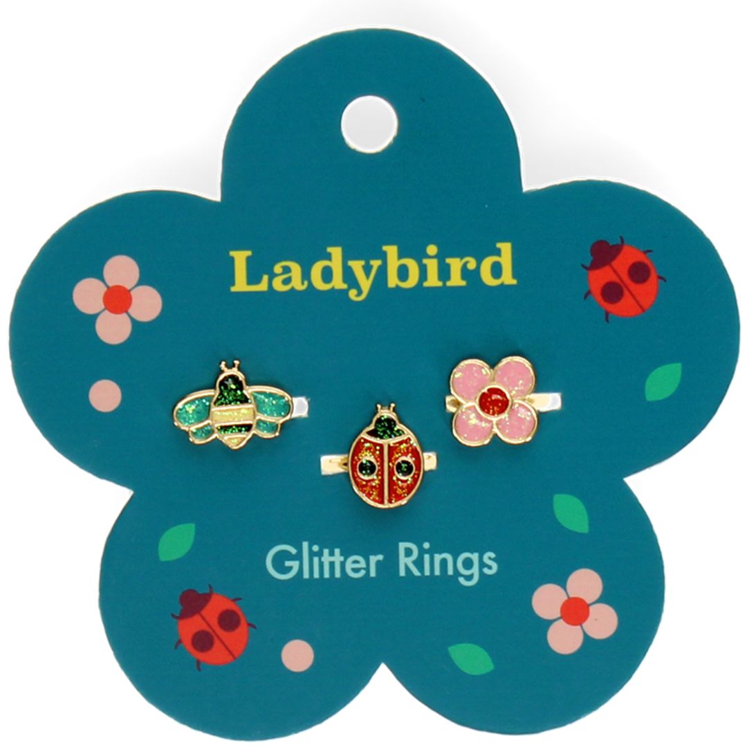 Rex London kinderringen glitter ladybird set op een bloemvormige verpakking met een bij, lieveheersbeestje en bloem.