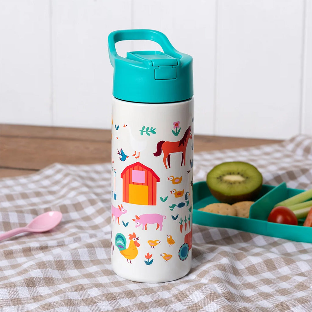 Drinkfles met boerderijthema op een geruite doek naast een lunchbox.