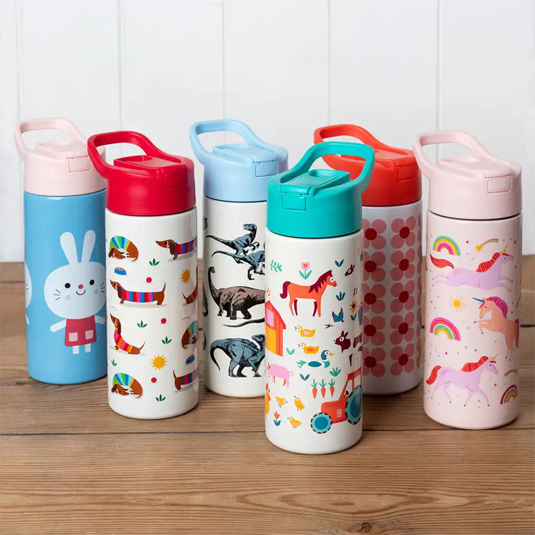 Een collectie Rex London kinderdrinkflessen met diverse thema's op een houten ondergrond.