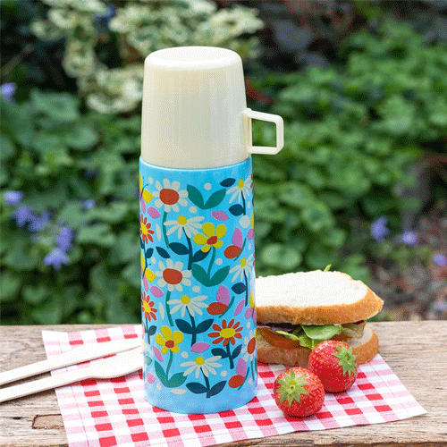Rex London RVS thermosfles met bloemen- en vlinderpatroon op een picknicktafel met een broodje en aardbeien.