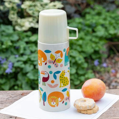 Rex London thermosfles met dierenpatroon op een houten tafel met fruit en koekjes.