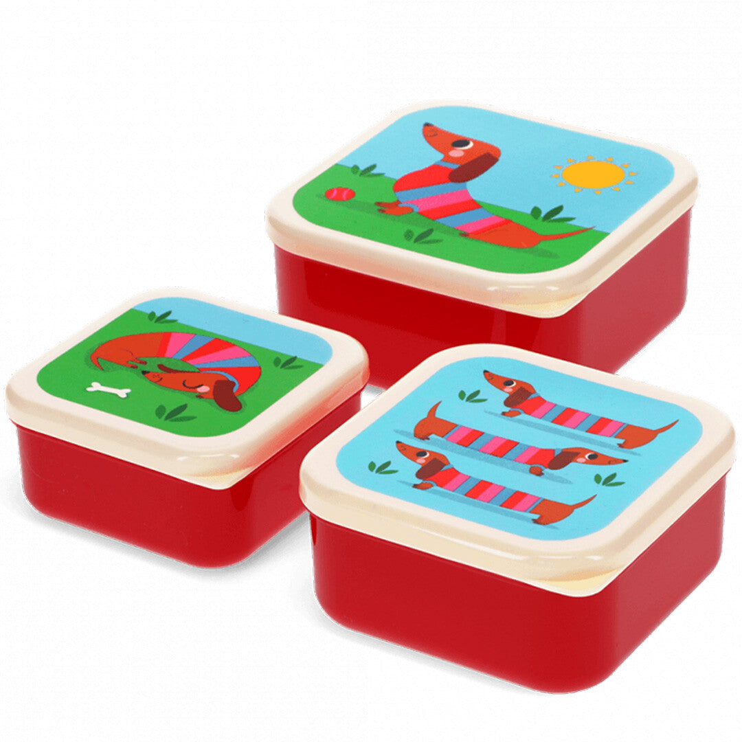 Drie Rex London snackdoosjes met rode onderkant en deksels met verschillende teckelillustraties.