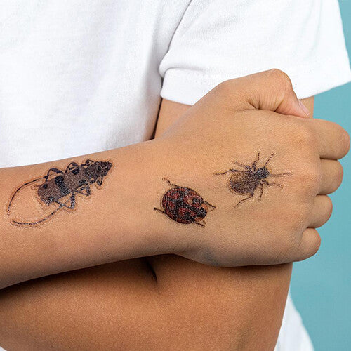 Arm van een kind met drie Rex London tijdelijke kever tatoeages.