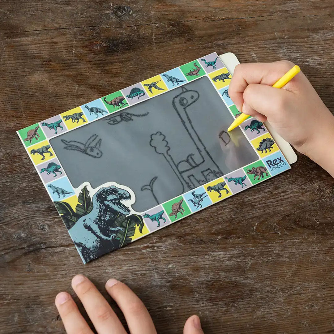 Een hand tekent met de gele stylus een dinosaurus op het Rex London tekenbord.
