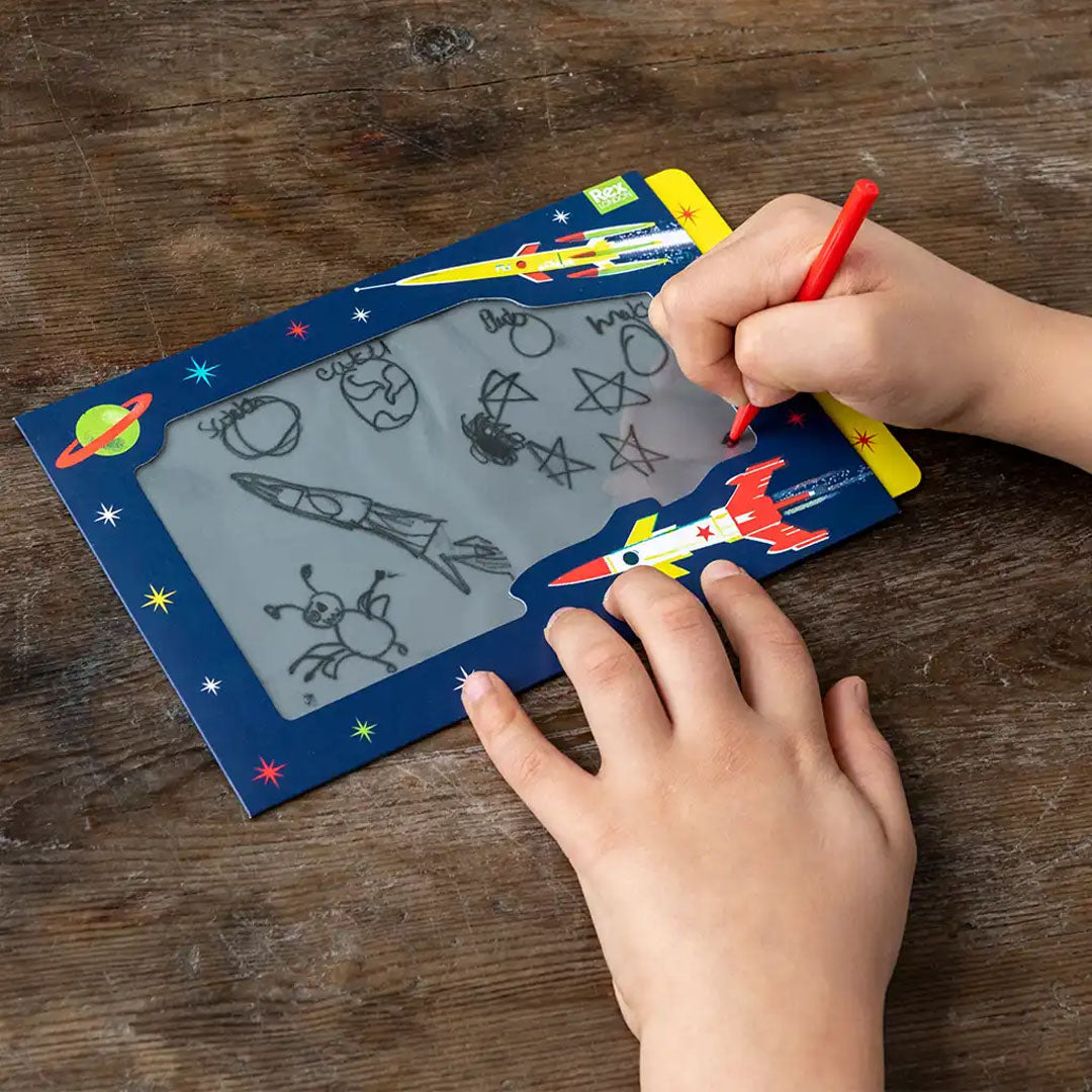Kind tekent met de rode pen op het Rex London speelgoedtekentablet met space age thema.
