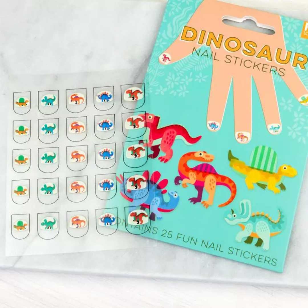 Een schuin bovenaanzicht van de Rex London dinosaurus nagelstickers verpakking naast een vel met losse stickers.