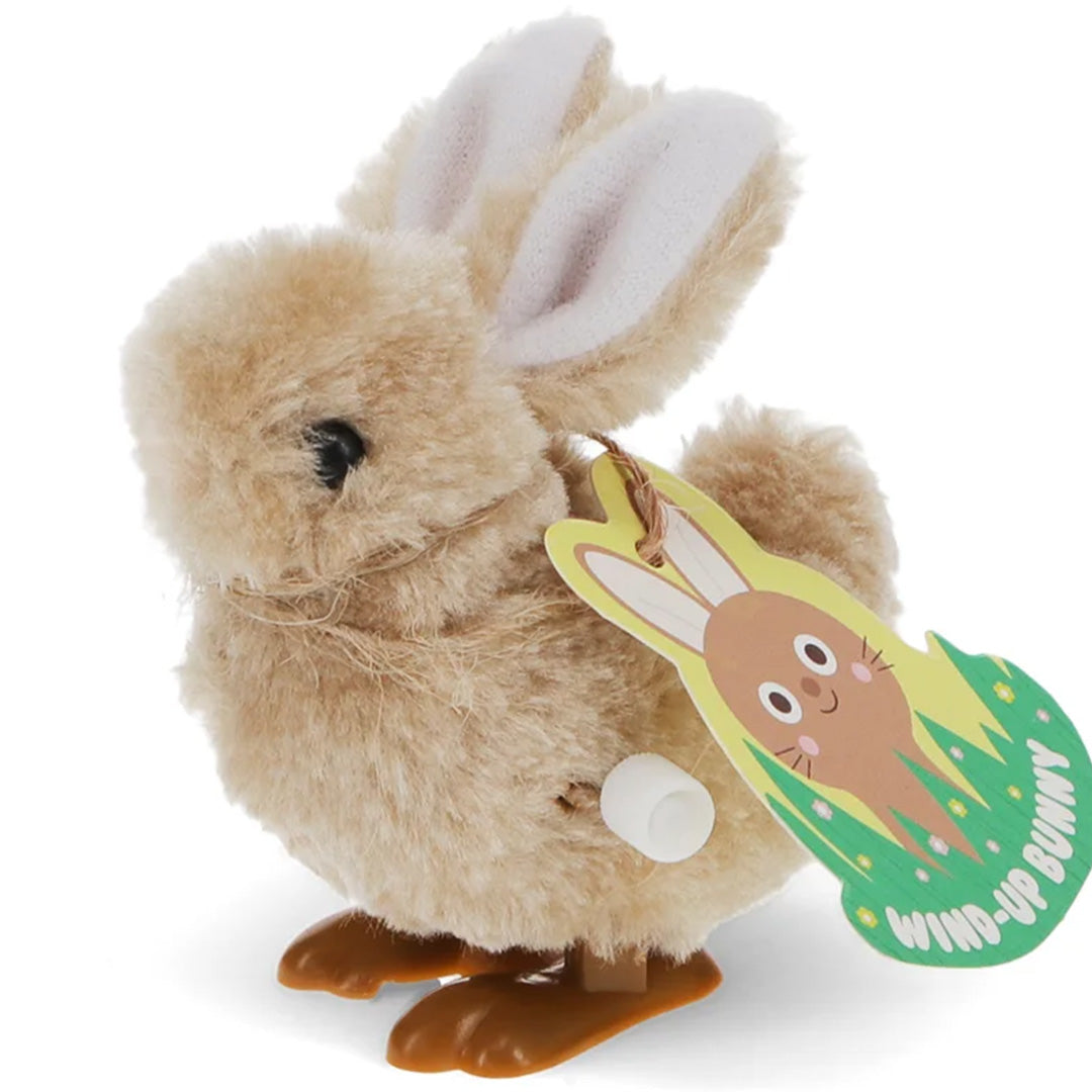 Rex London opwindbaar konijntje van beige pluche met een geel label met konijnenillustratie.