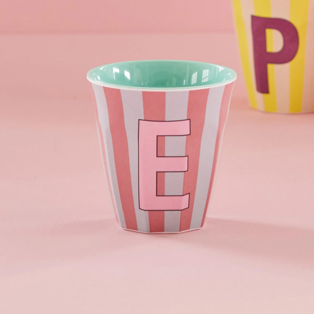 rice alfabetbeker met roze en lichtblauwe strepen en de letter E op een roze ondergrond.