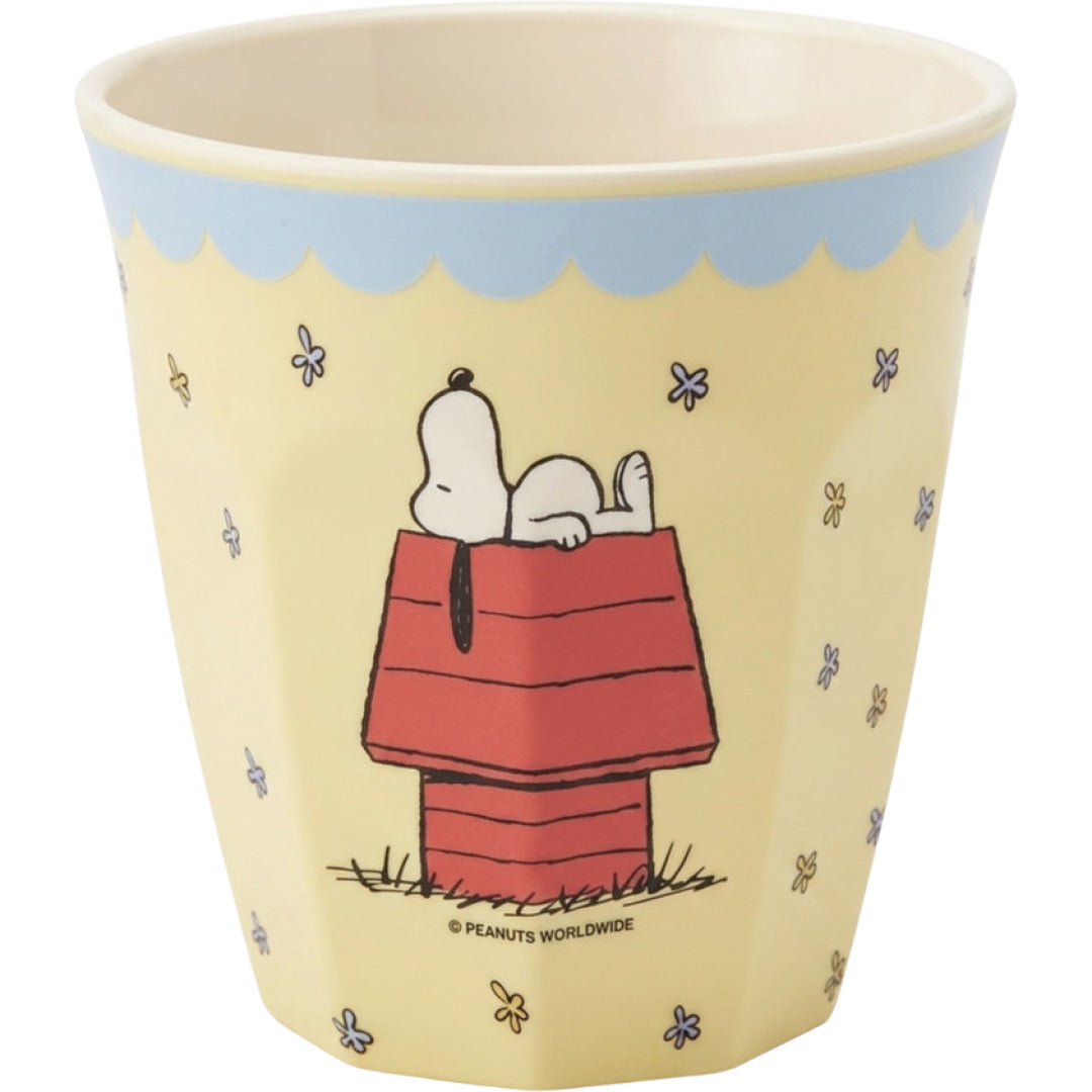 Gele rice kinderbeker met een afbeelding van Snoopy liggend op zijn rode hondenhok en kleine bloemetjes.