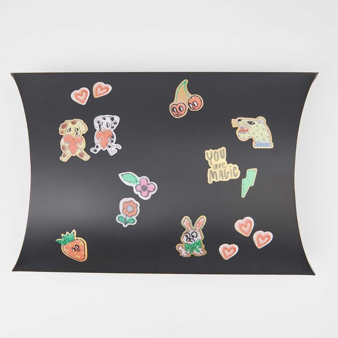 Een collectie van diverse Rico Design airbrush-stijl stickers met afbeeldingen van dieren, fruit, bloemen en harten op een zwarte ondergrond.