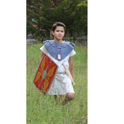 Jongen in Romeinse kleding loopt met het rode speelgoedschild in een grasveld.