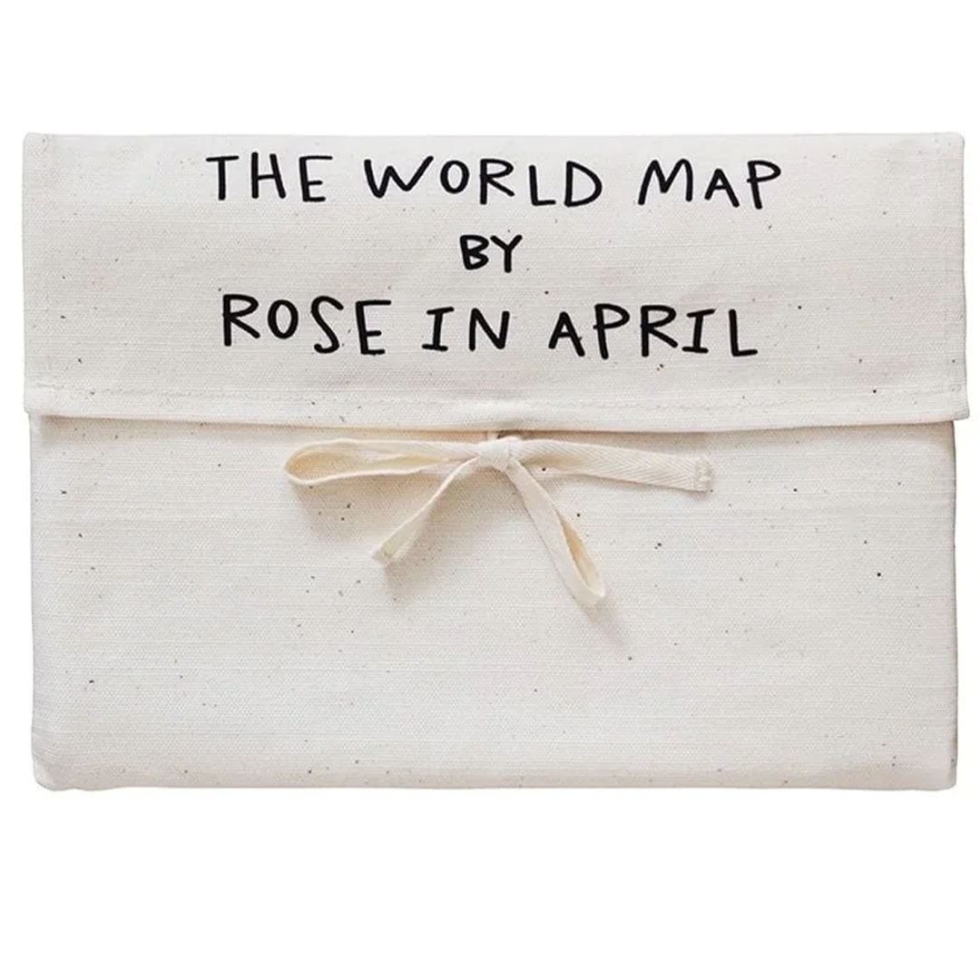 De verpakking van het rose in April wandkleed, een beige katoenen zakje met de tekst 'THE WORLD MAP BY ROSE IN APRIL'.