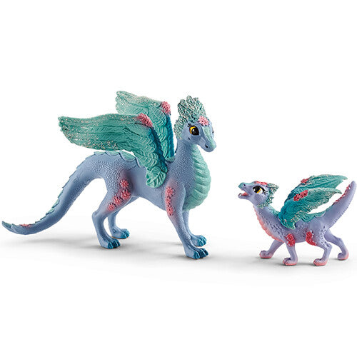 Schleich Bayala bloemendraak speelgoedfiguur met baby, beide blauw met roze bloemen en glittervleugels.