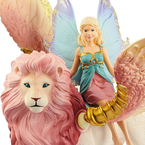 Detailopname van het Schleich bayala elfje met blauwe vleugels en de roze manen van de gevleugelde leeuw.
