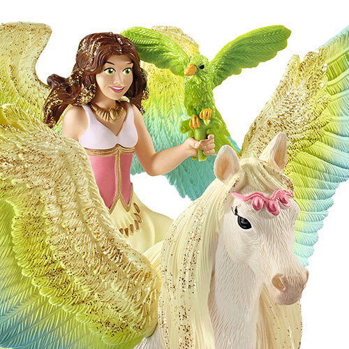 Detailopname van de Schleich speelgoedfiguur van de lachende fee met papegaai op de regenboog glitterpegasus.