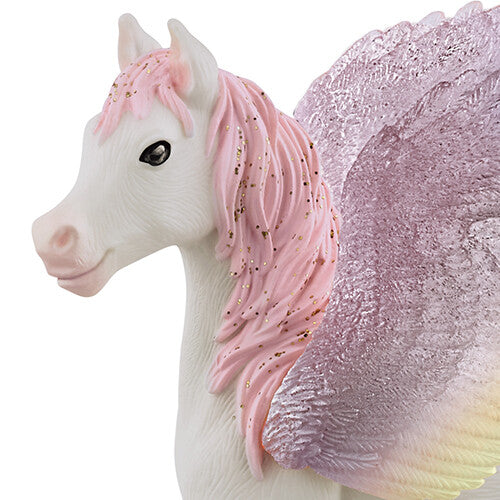 Detailopname van het pegasusveulen speelgoedfiguurtje, met de kop, roze manen en glittervleugel.