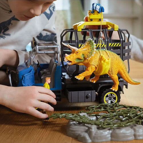 Kind speelt met de Schleich dinosaurusspeelset, met een triceratops die door een kraan wordt opgetild.