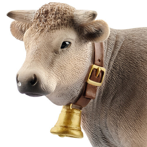 Detailfoto van de kop van een Schleich Braunvieh koe met bel en halsband.