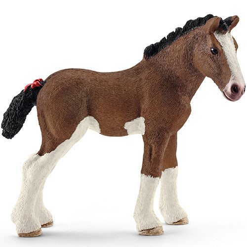 Schleich plastic dierenfiguurtje van een bruin-wit Clydesdale veulen met een rood lintje in de staart.