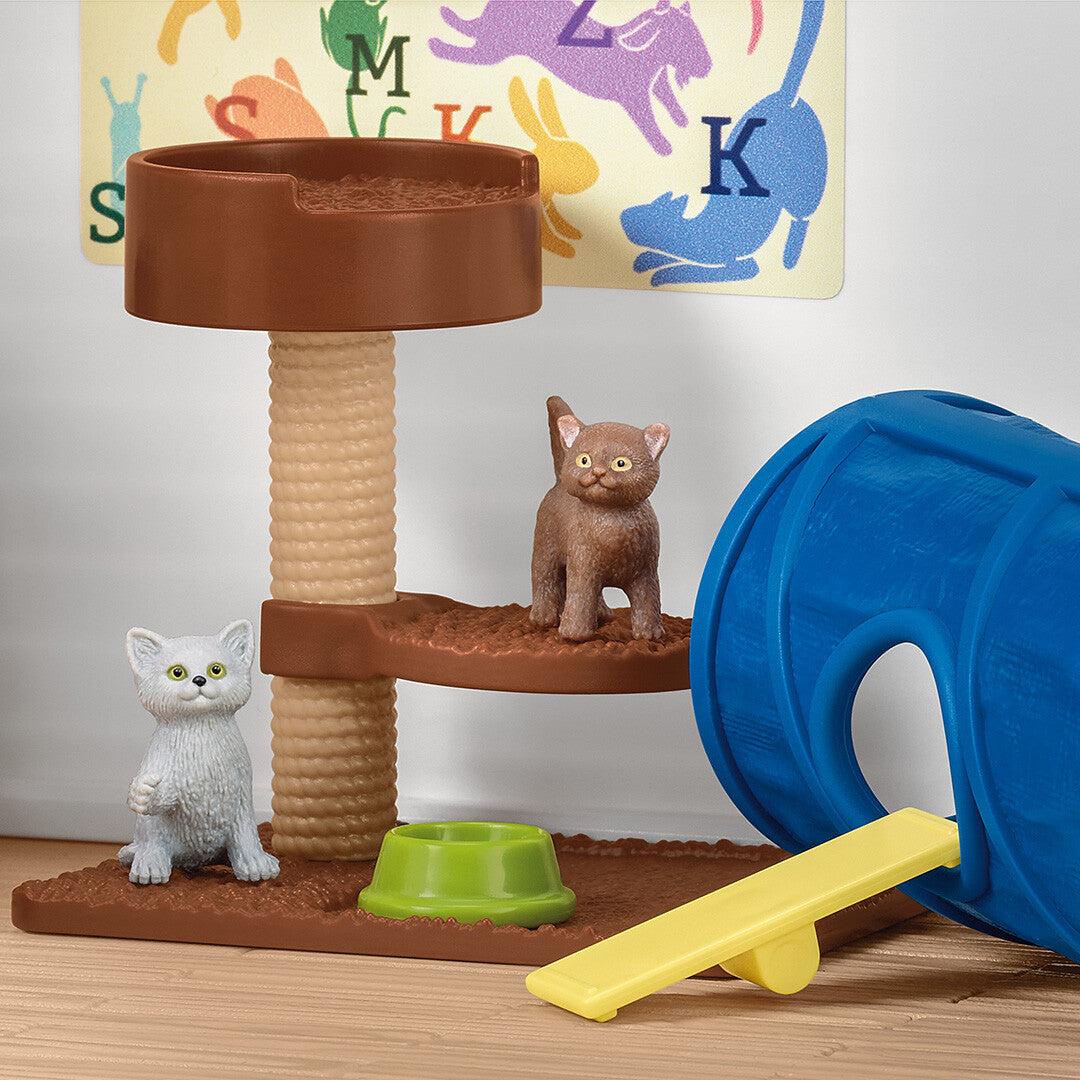 Detail van de Schleich dierenhotel speelset met een krabpaal, twee katten, een voerbakje, een wip en een blauwe tunnel.