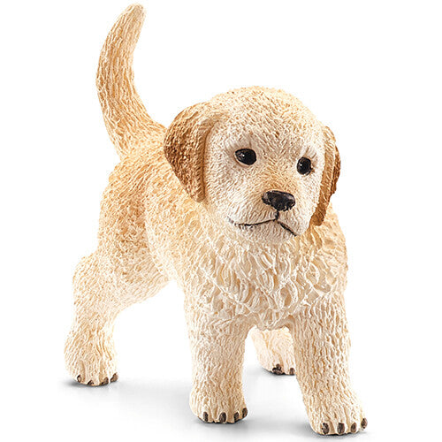 Schleich dierenfiguurtje van een beige golden retriever pup, staand en schuin van voren gefotografeerd.