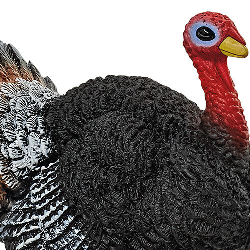 Detailopname van de rode kop en zwarte, getextureerde romp van het Schleich kalkoen speelgoedfiguur.