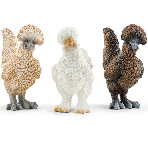 Schleich dierenfiguurtjes van drie kippen: een lichtbruine, een witte en een donkerbruine.