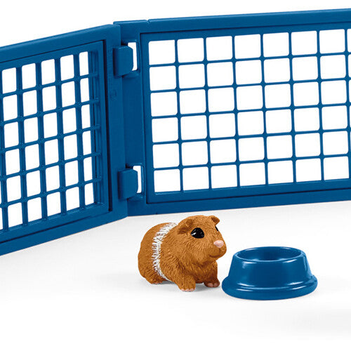 Detail van de Schleich speelset met een bruine cavia, een blauwe voerbak en een blauw hek.