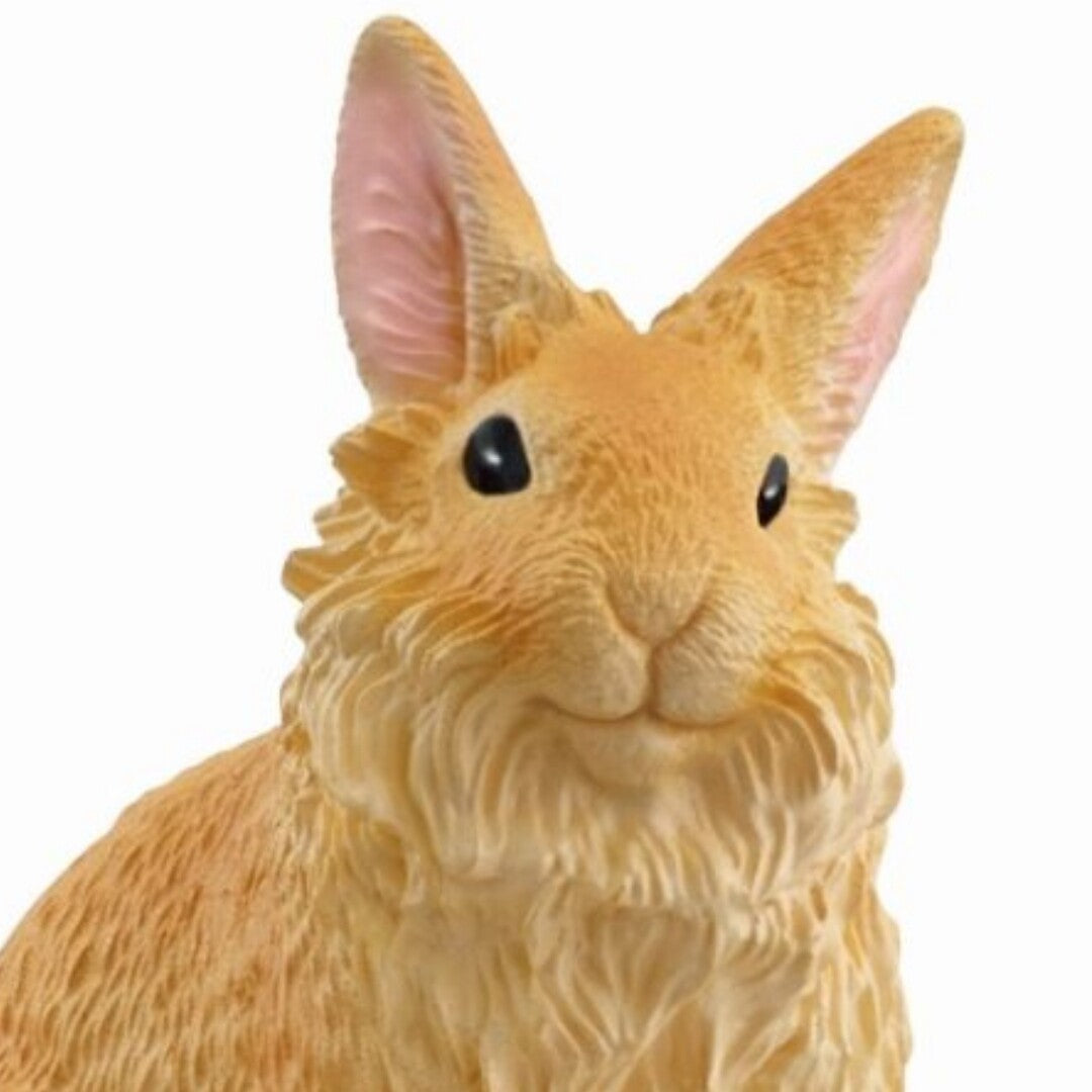 Detailopname van het gezicht van het Schleich oranje plastic leeuwenkop konijn.