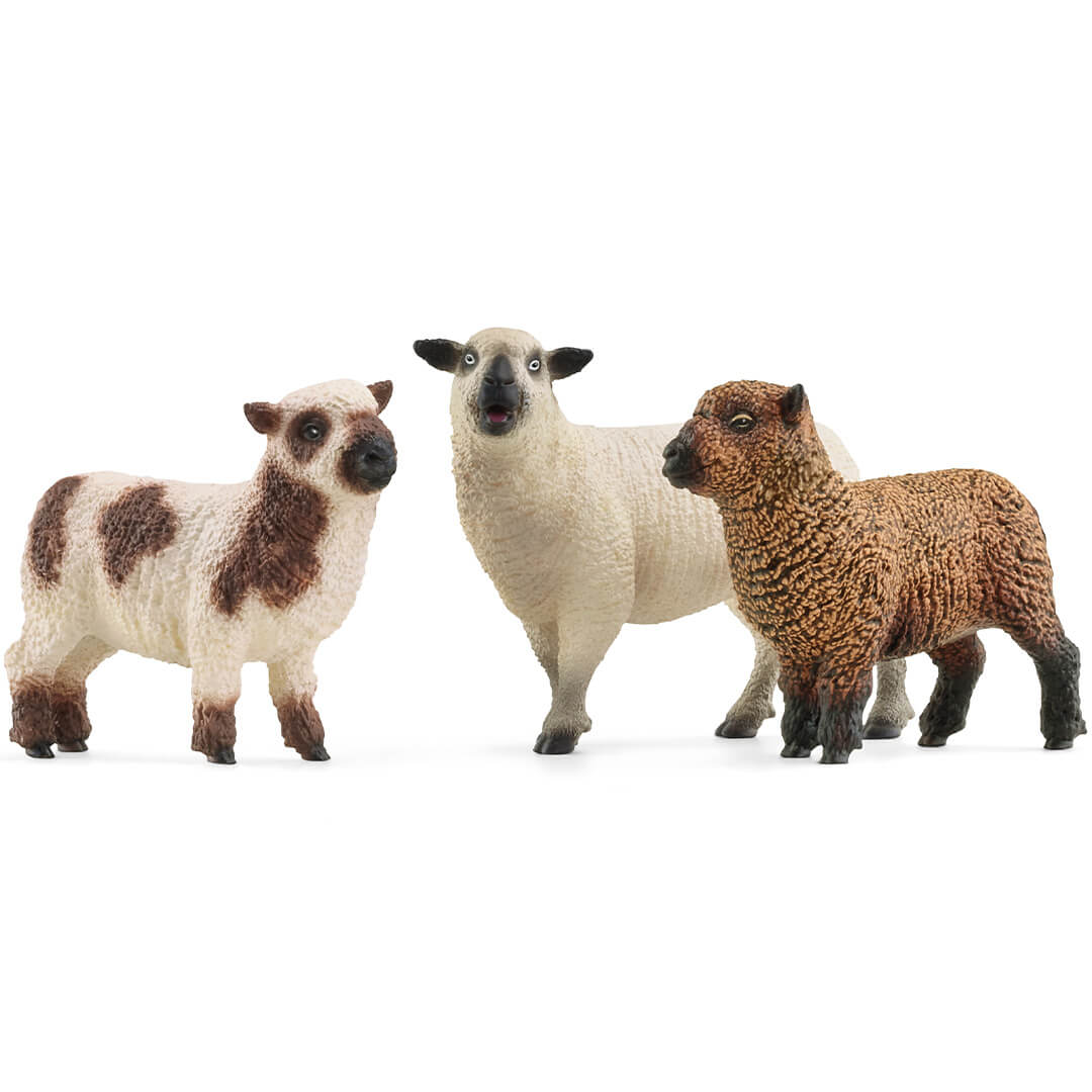 Schleich dierenfiguurtjes van een wit schaap, een bruin lam en een wit met bruin gevlekt lam.