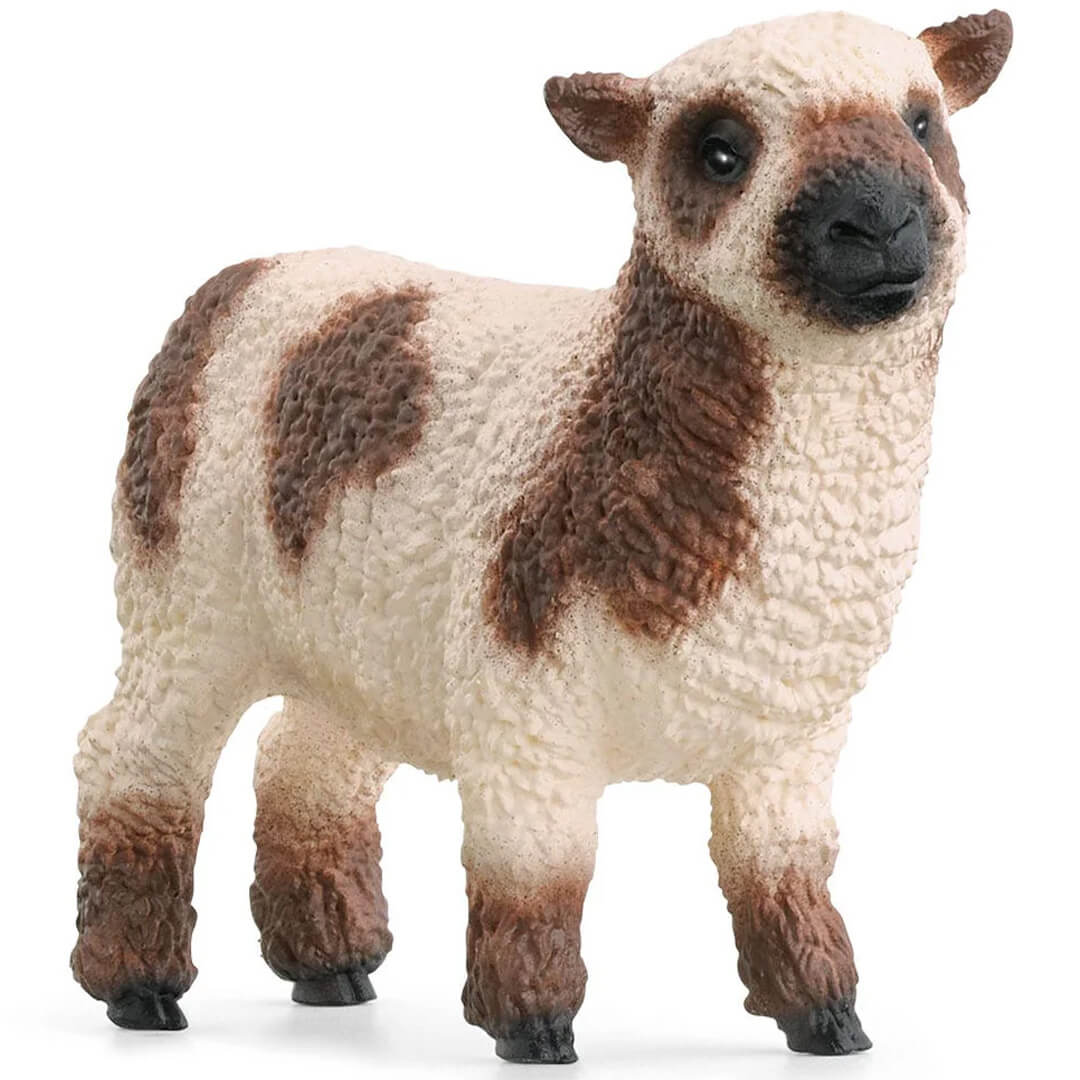 Schleich dierenfiguurtje van een wit met bruin gevlekt lammetje.
