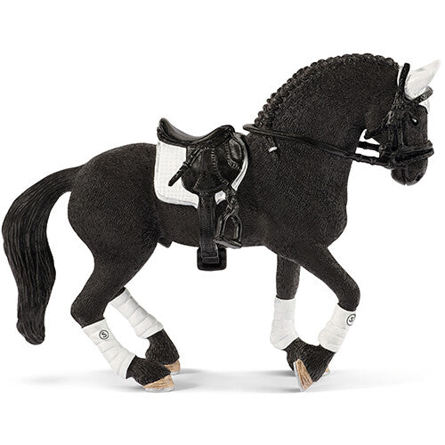 Schleich speelgoedfiguurtje van een zwarte Friese hengst met zadel, hoofdstel en witte beenbeschermers.
