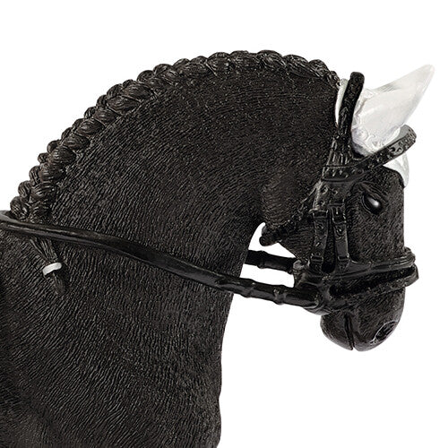 Close-up van de kop van het Schleich speelgoedpaard, een zwarte Friese hengst met gevlochten manen en hoofdstel.