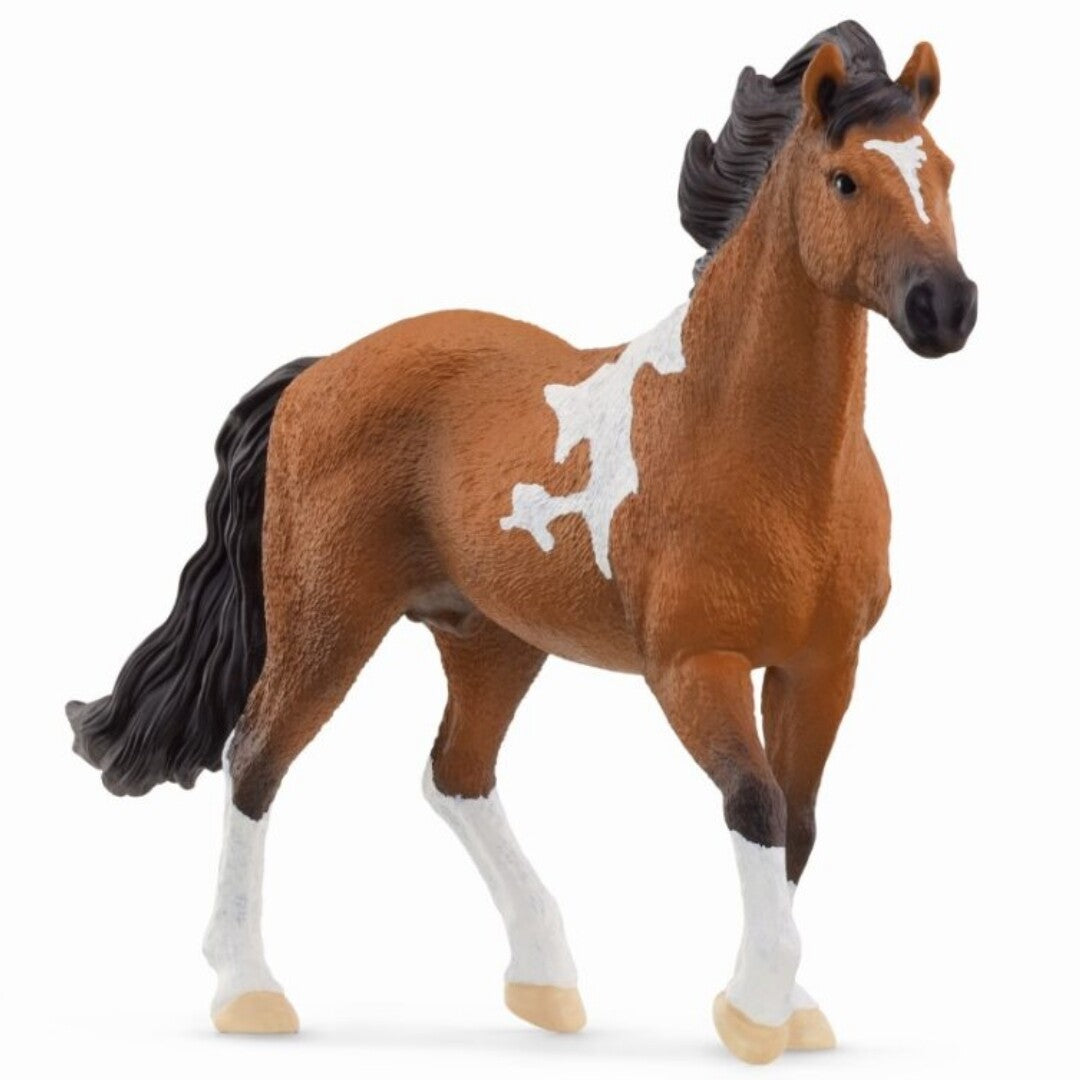 Schleich dierenfiguurtje van een bruin paard met witte vlekken, staand.