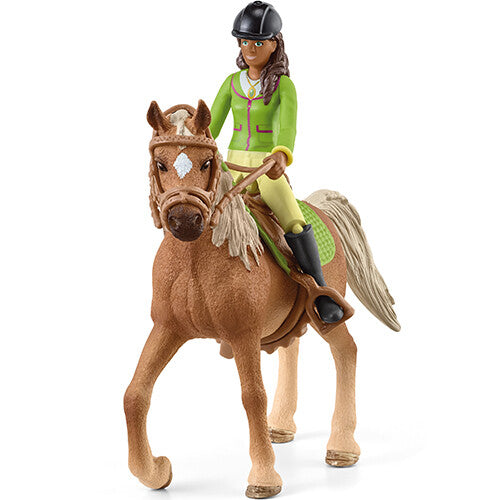 Schleich speelgoedfiguur van Sarah op Mystery, een bruin paard met hoofdstel en zadel.
